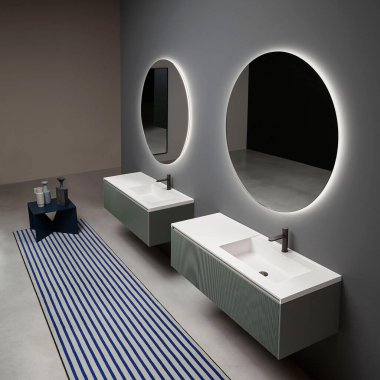 Modern lüks banyo. Minimum İskandinav tarzı. Büyük yuvarlak aynaları, lavabosu ve musluğu var.