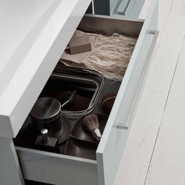 Banyonun içinde kozmetik ürünleri ve hijyen ürünleri olan beyaz açık çekmece.