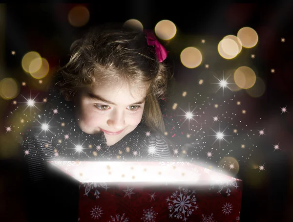 Barn öppna en magisk presentförpackning Royaltyfria Stockbilder