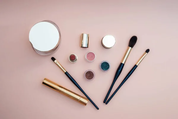 Set kosmetik kecantikan untuk wajah perempuan dan makeup mata pada latar belakang merah muda . — Stok Foto