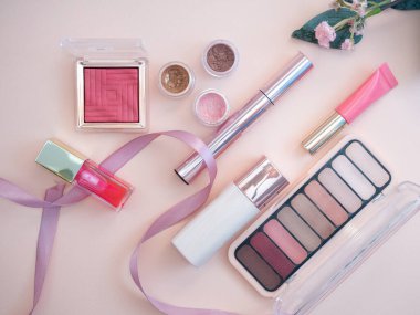 Pembe arka planda kadın yüzü ve göz makyajı için makyaj seti. fotoğraf