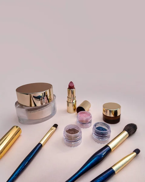 Conjunto de cosméticos de belleza para la cara femenina y maquillaje de ojos sobre fondo rosa . — Foto de Stock