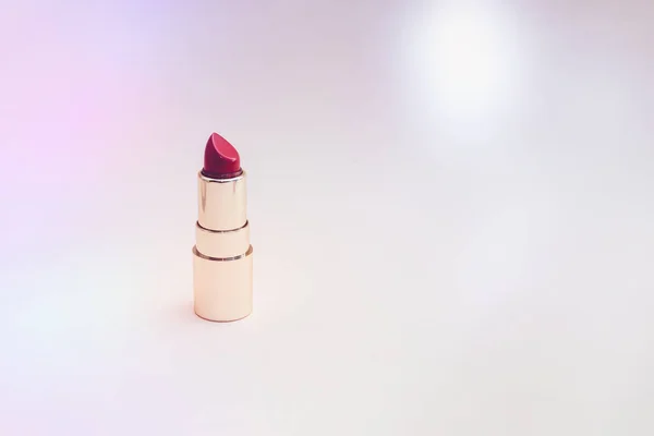 Red lipstick in a gold case on a pink background — Stock Photo, Image
