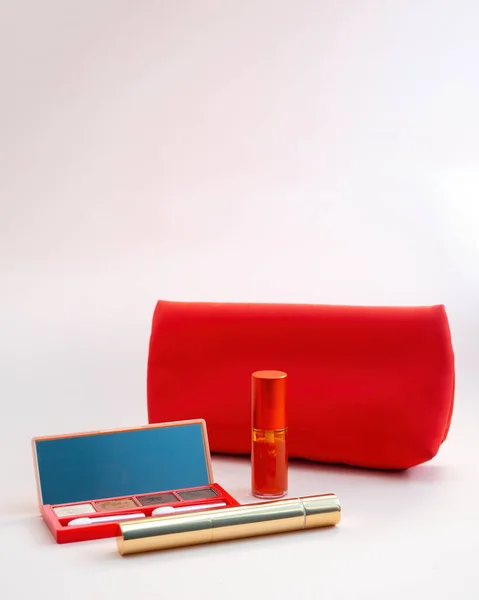 Widok z góry kosmetyki wyróżniające się z czerwonej torby kosmetycznej na różowym tle — Zdjęcie stockowe