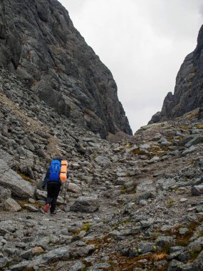 Sırt çantalı genç bir turist cansız kayalık bir geçitten geçiyor..