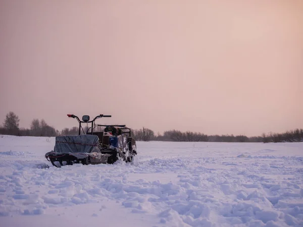 Winter fishing. Ice fishing. Fisherman, fishing on the ice. Electric snowmobile for fishing. Russia. February 20, 2016 photo