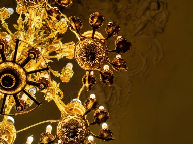 Şatafatlı iç avizenin mumları ve karanlık bir arka planı var. Asil şamdan tavandan sarkıyor. fotoğraf