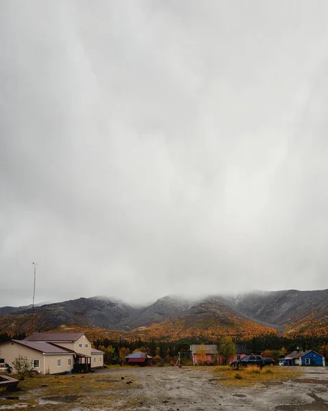 A gray autumn day at the KSS base in the Khibiny. Houses and cars against the backdrop of autumn mountains. — Stock Photo, Image