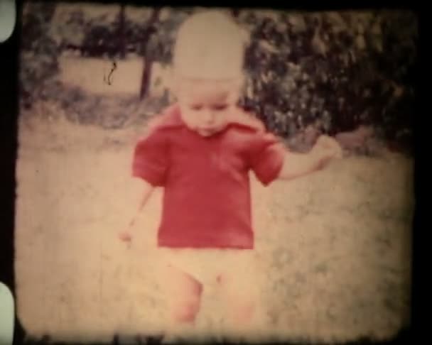 Little boy plays with ball, falling on the ground and laughing. 1960s, vintage 8mm film footage. — Stock Video