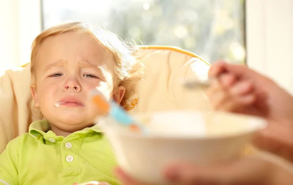 Kid is very disappointmented about porridge. — Stock Photo, Image