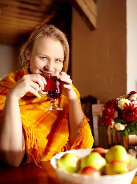 Jovem mulher está bebendo chá e sorrindo . — Fotografia de Stock