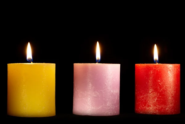 Drei Kerzen auf schwarz. — Stockfoto