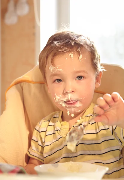 Two year old boy eats porridge in the morning. — Stock Photo, Image