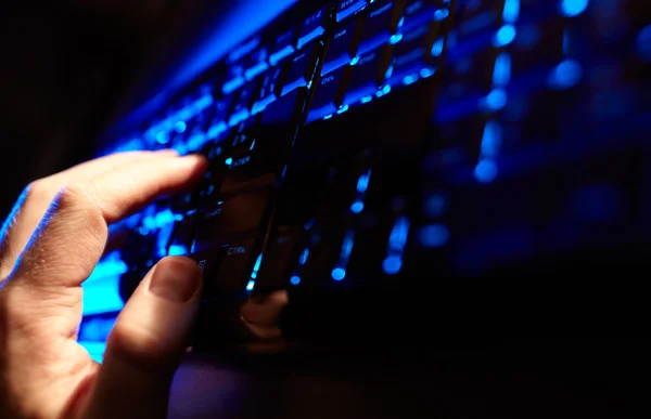 Die Hand des Mannes tippt auf einer blauen Tastatur. — Stockfoto