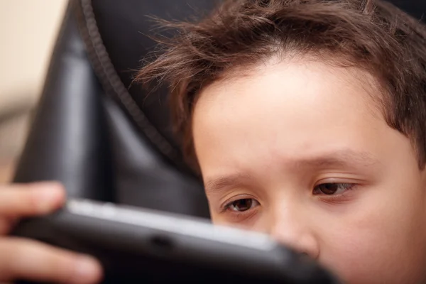 Menino cansado de jogar seu console de jogo portátil . — Fotografia de Stock