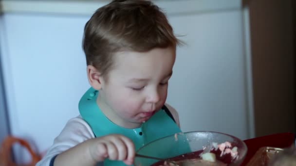 Niño de dos años está comiendo sopa de pescado del plato — Vídeos de Stock