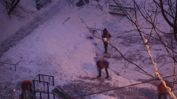 Уличные уборщики в оранжевой форме убирают снег — стоковое видео