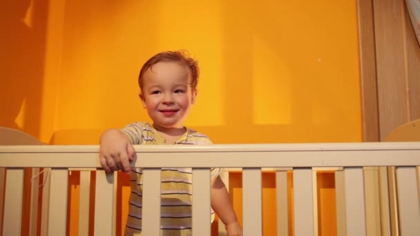 Jongen glimlachend in kinderbox — Stockvideo