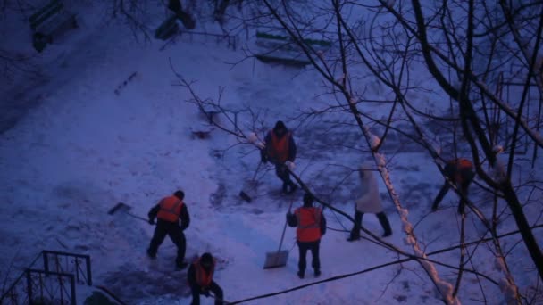 Nettoyeurs de rue en uniforme orange enlevant la neige — Video