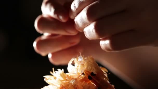 Les mains des femmes nettoient les crevettes 