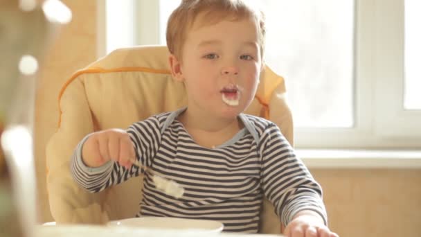 Petit garçon mange du porridge le matin — Video