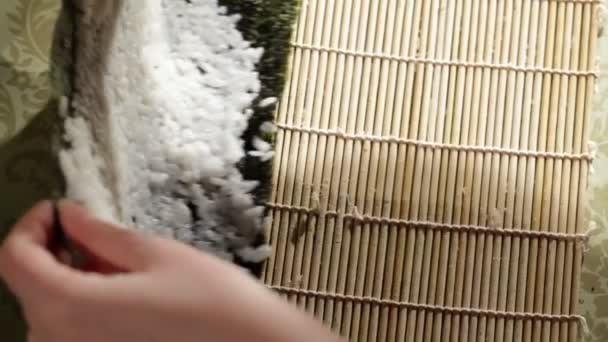 Reis auf Nori geben. macht Sushi-Brötchen. Blick aus dem Hochwinkel — Stockvideo