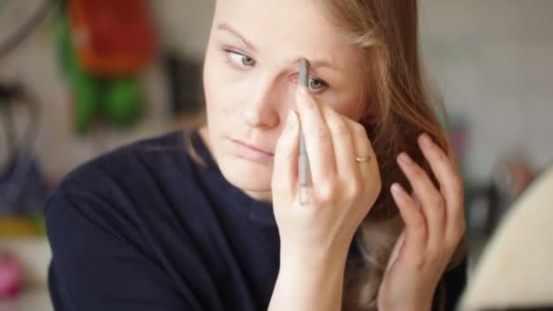 Mujer joven moldeando sus cejas. Primer retrato con luz natural del sol de la mañana — Vídeos de Stock