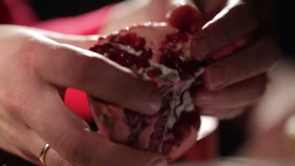 Женские руки удаляют семена из граната — стоковое видео