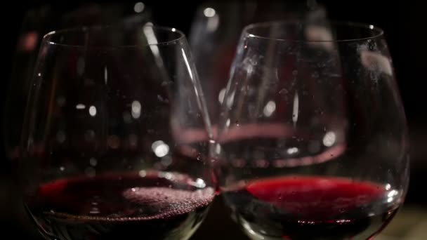 Rode wijn wordt gegoten in de glazen. macro schot — Stockvideo