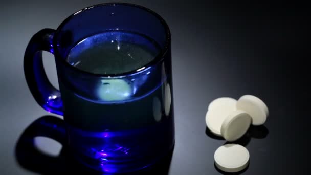 Tablet rozpouštění v modré sklenice vody. časová prodleva — Stock video