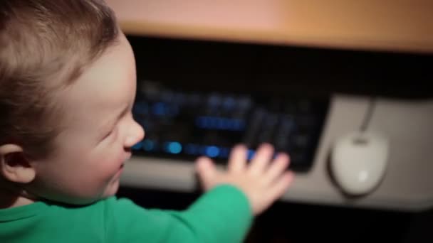 Menino de dois anos está brincando com teclado — Vídeo de Stock