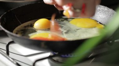 bir tavada kızartma yumurta. domates dilimleri ekleme.