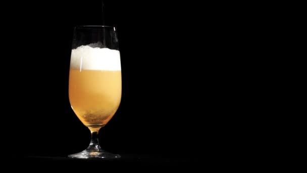 Bière coulée en verre sur fond noir .