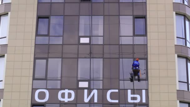 Man washes the windows of office building — Stock Video