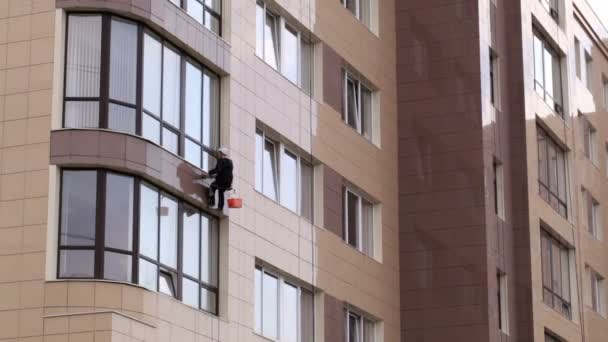 Man washes windows on a skyscraper — Stock Video