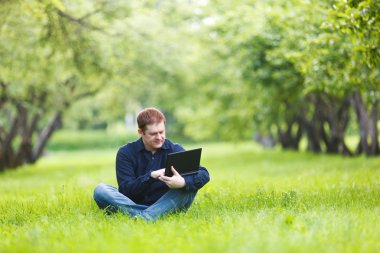 man aan het werk met laptop in het park.