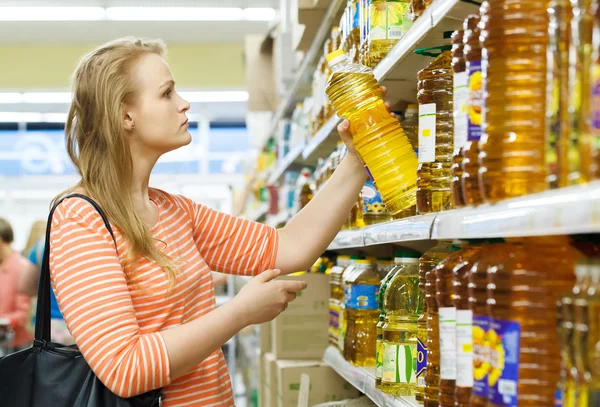 Young woman buys sunflower oil — Stock Photo, Image