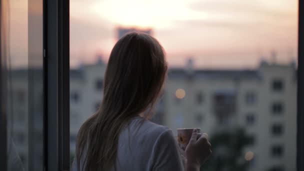 ウィンドウにお茶のカップを持つ若い女 — ストック動画