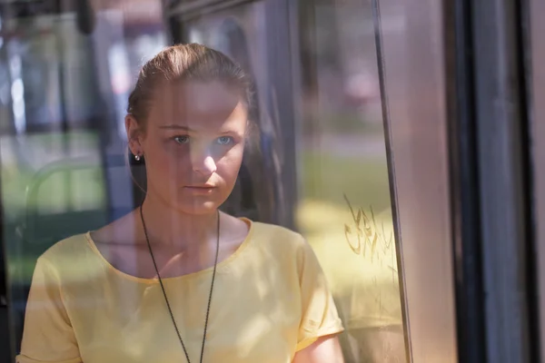 Jonge vrouw in het geel rijdt de bus — Stockfoto