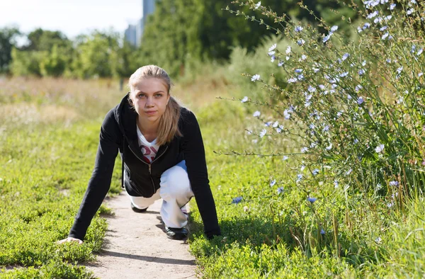 Junge Frau macht Liegestütze im Park — Stockfoto