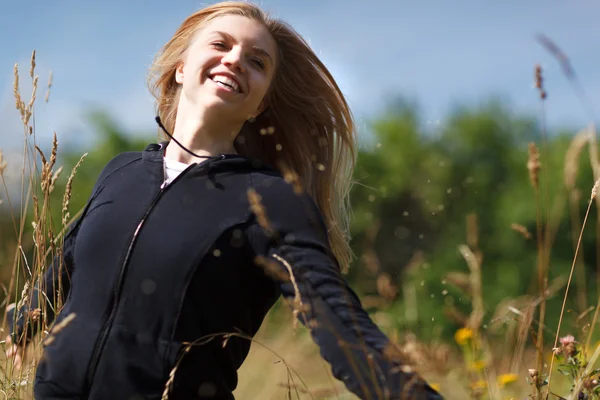 Jovem menina feliz correndo no campo — Fotografia de Stock