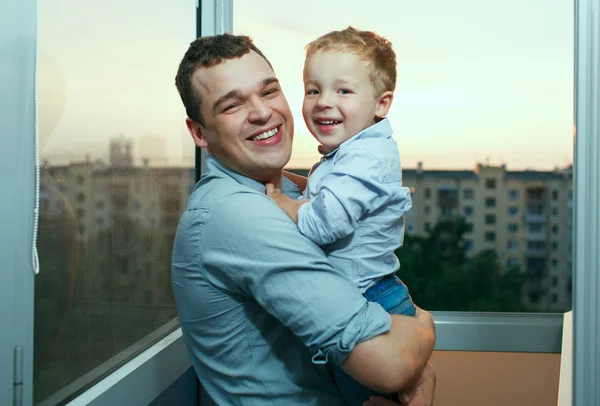 Giovani padre e figlio sorridenti sul balcone . — Foto Stock