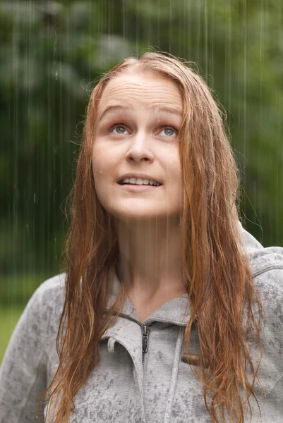 A lány élvezi az eső a parkban. — Stock Fotó
