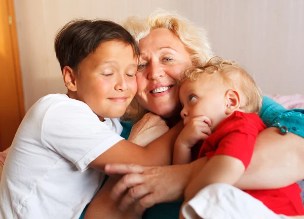 Happy grandmother hugging with her grandsons — Stock Photo, Image