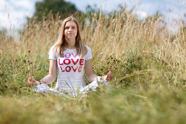 Young girl meditating in the field — Stock Photo, Image