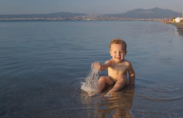 Милый маленький мальчик, плескающийся в море — стоковое фото