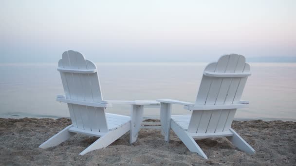 Houten dek stoelen op een strand — Stockvideo