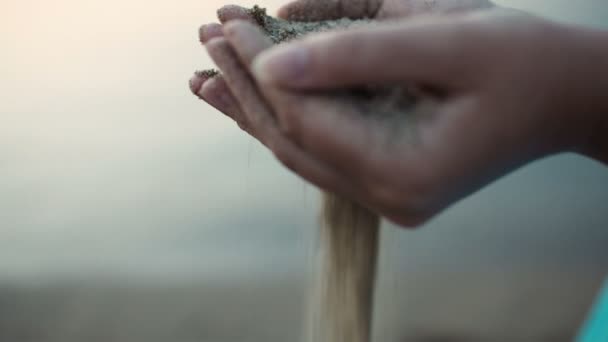 Close-up van de hand van een vrouw druilerig zee zand — Stockvideo