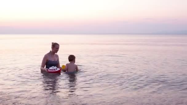 Amare la madre e il suo bambino bagnarsi nell'acqua del mare — Video Stock