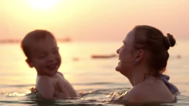 Madre cariñosa y su hijo pequeño bañándose en el agua del mar — Vídeos de Stock